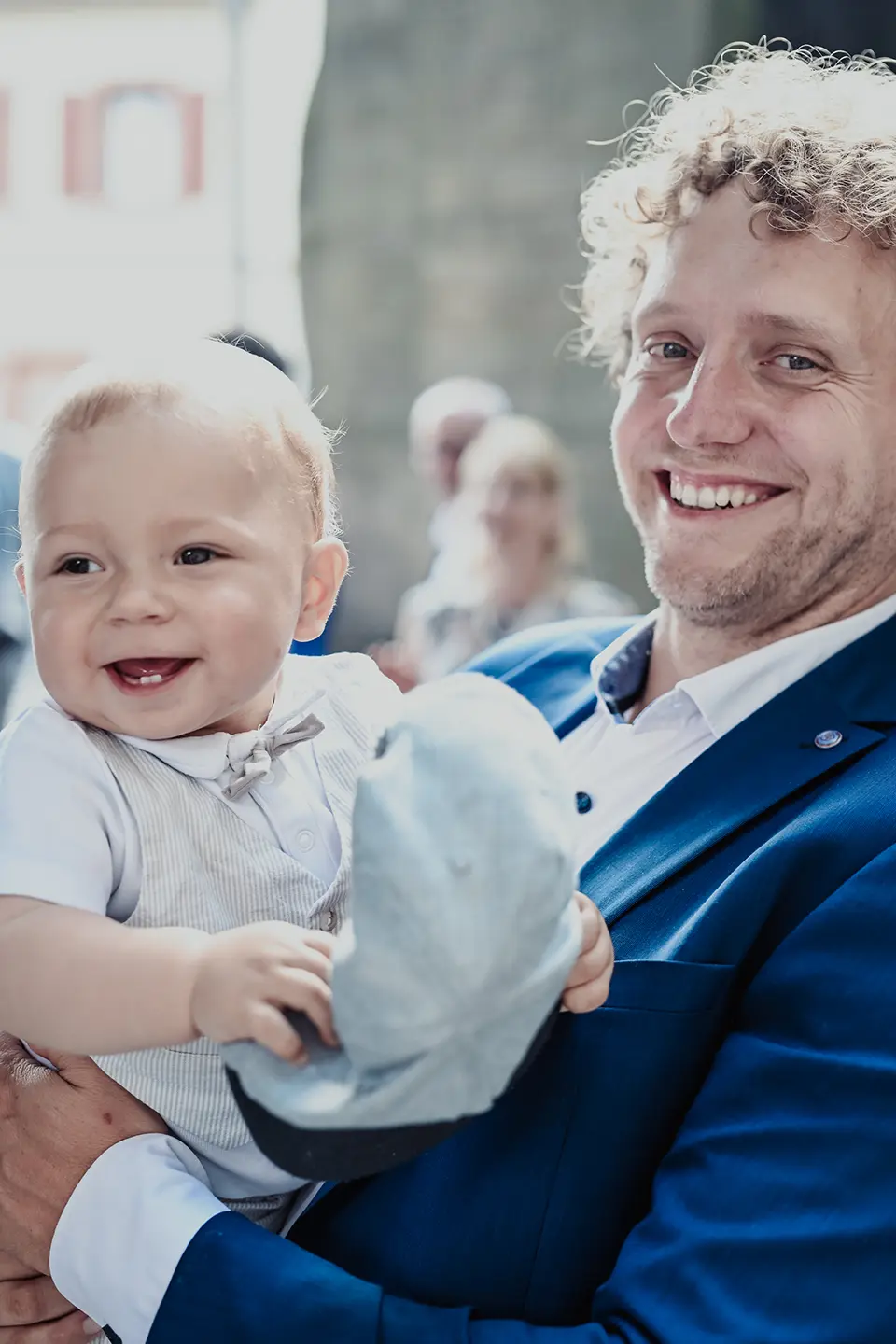 Portrait von einem Vater mit kleinem Sohn auf dem Arm, der zwei Zähnchen hat.