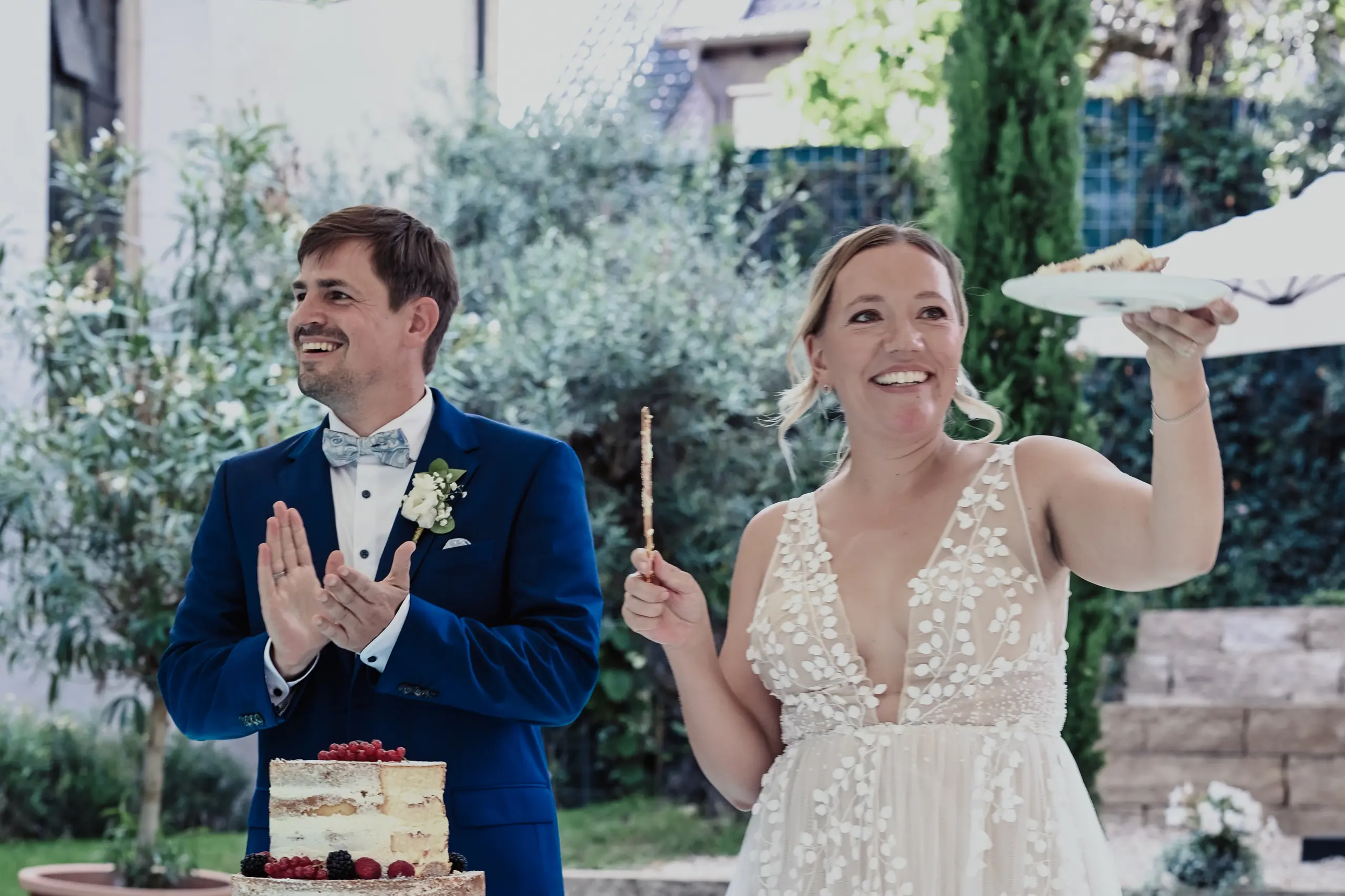 Hochzeitspaar beim Kuchen verteilen.