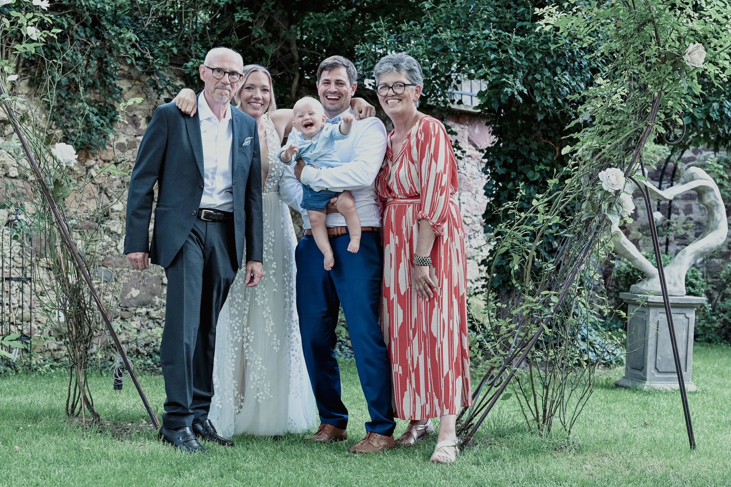 Lachendes Hochzeitsgruppenfoto mit Baby.