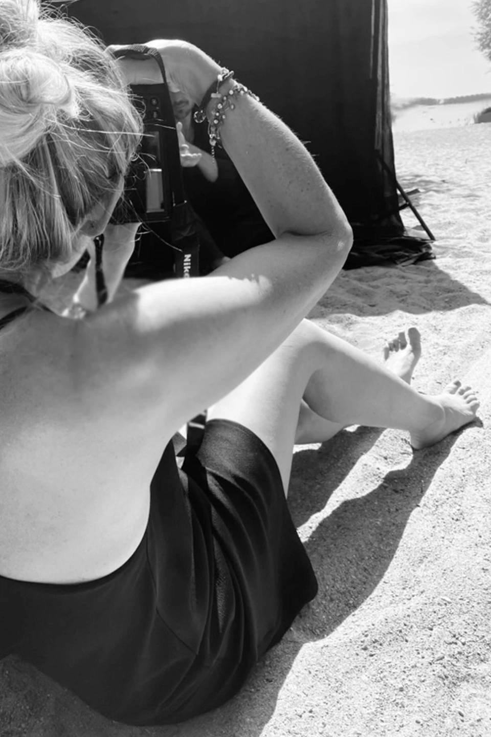Susanne Watrin beim Shooten am Bodensee, im Sand sitzend.