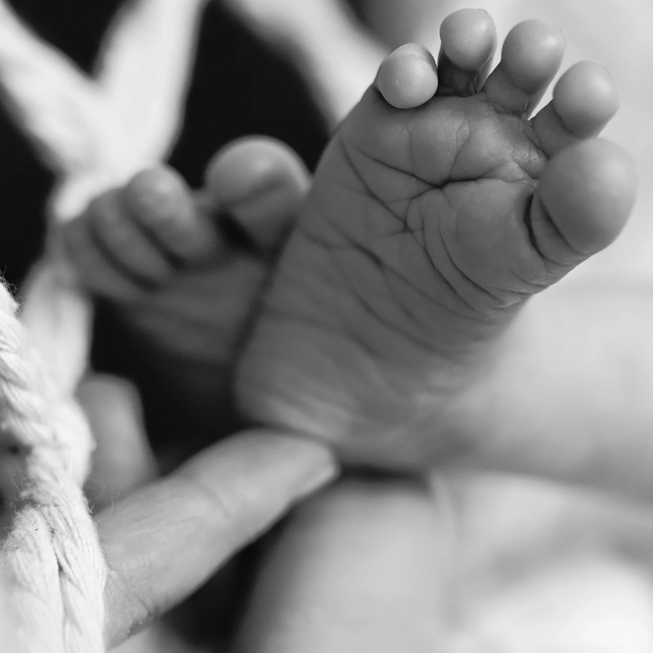 Babyfuß der aus einer Schaukel herausguckt.