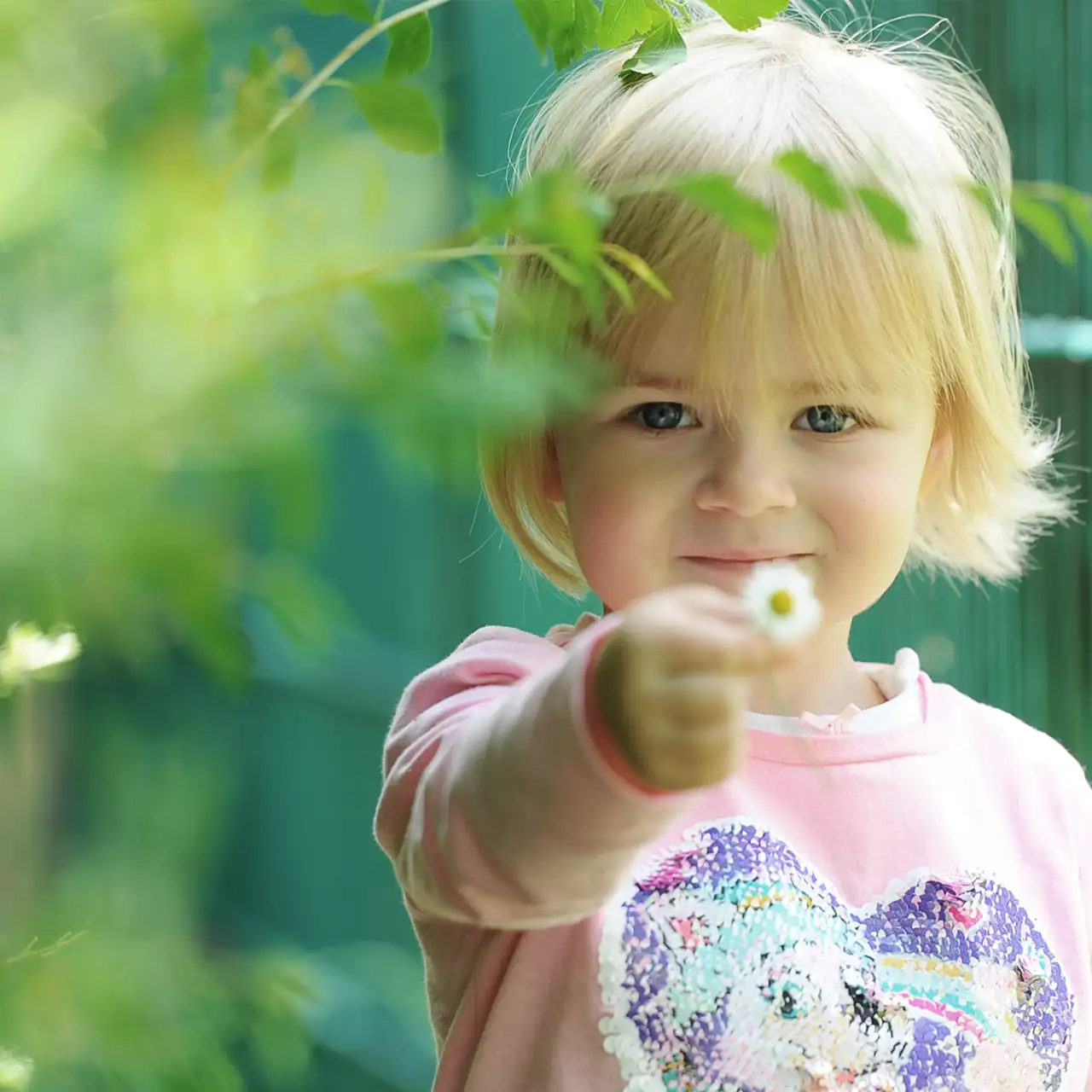 Kindergartenfoto eines Mädchens mit Gänseblümchen.